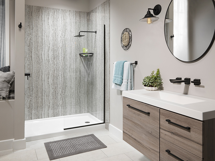 Walk-in shower with grey stone-look wall panels and matte black fixtures beside a wood-effect floating vanity